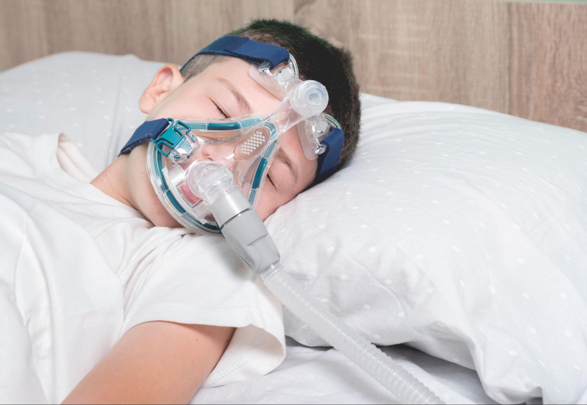 Patient wearing a full face CPAP mask while sleeping comfortably.