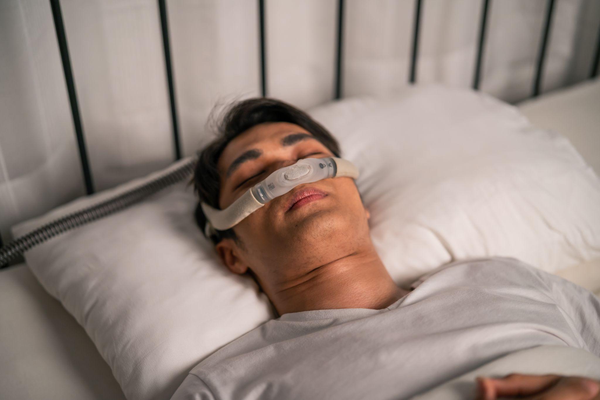 man using CPAP machine while sleeping