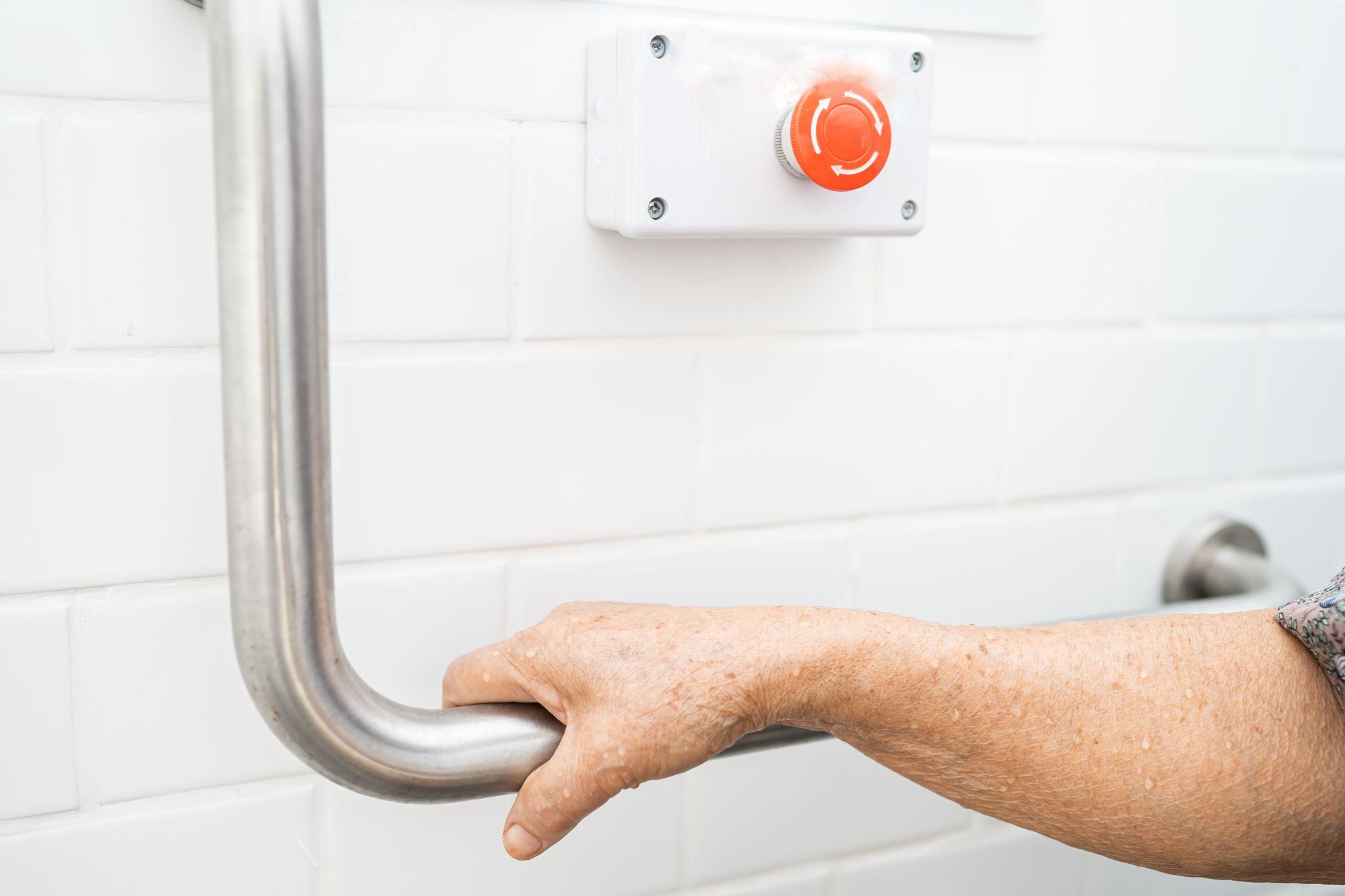 elderly person using grab bar in bathroom