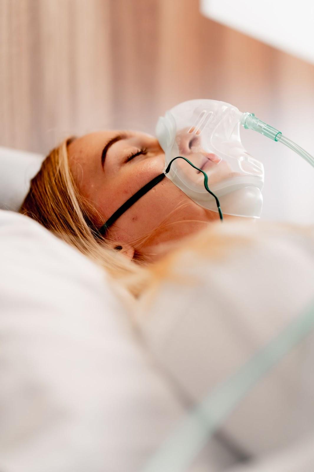 Woman resting with a breathing mask during sleep therapy.