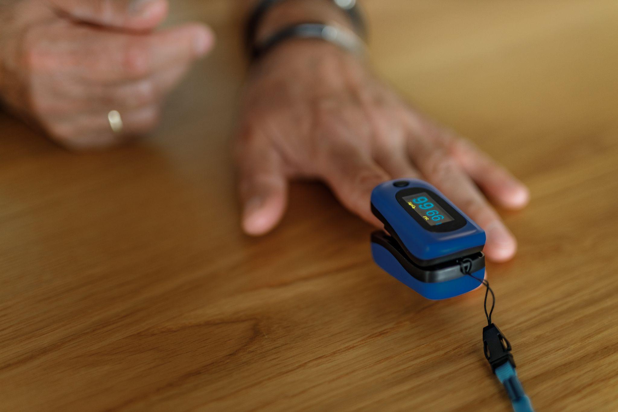 person using pulse oximeter