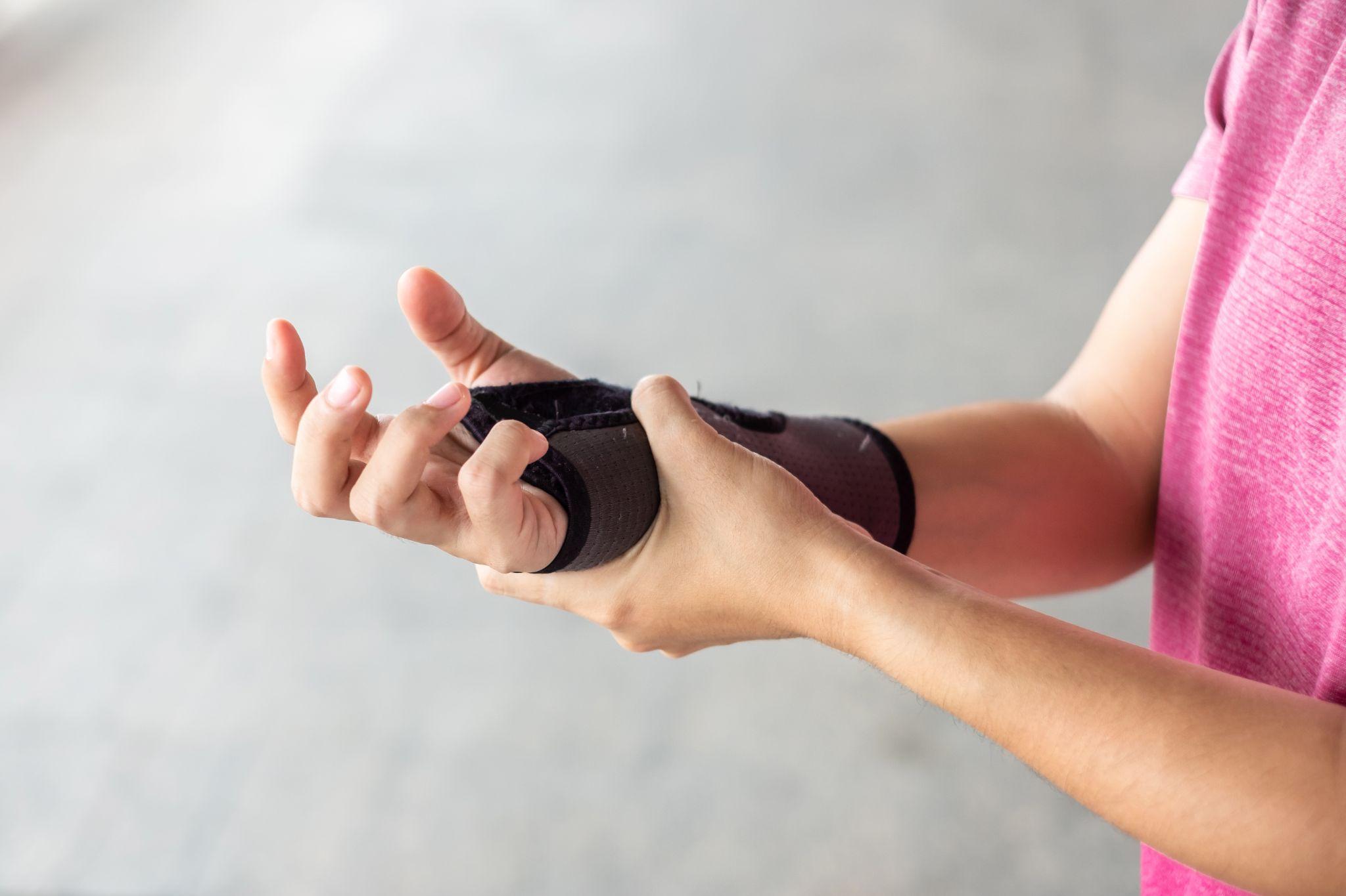woman holding her wrist brace