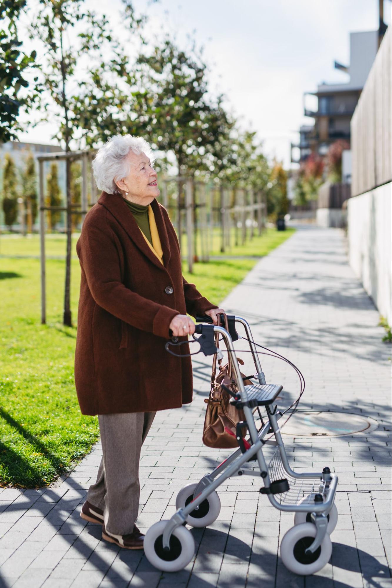 Senior woman walking outdoors with rollator