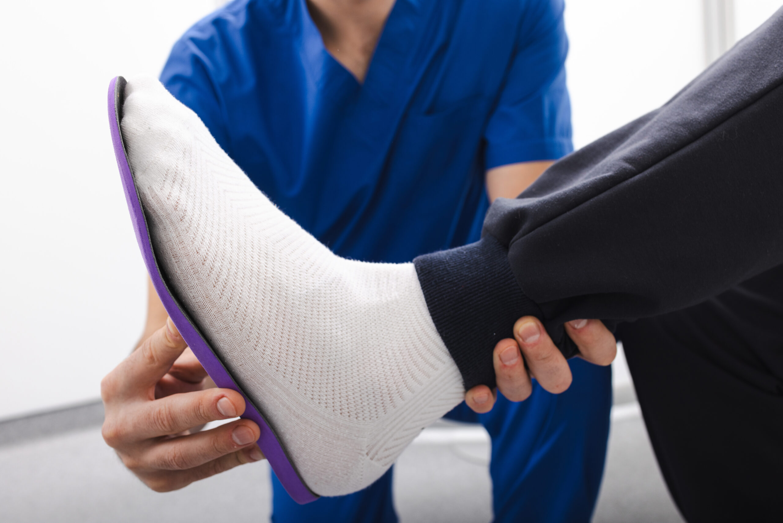 Specialist fitting a patient with a supportive orthotic device