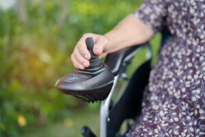 Hand operating joystick on a power wheelchair, a common type of durable medical equipment for mobility support