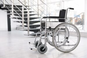 Wheelchair positioned near indoor stairs, highlighting durable medical equipment maintenance for mobility safety and longevity