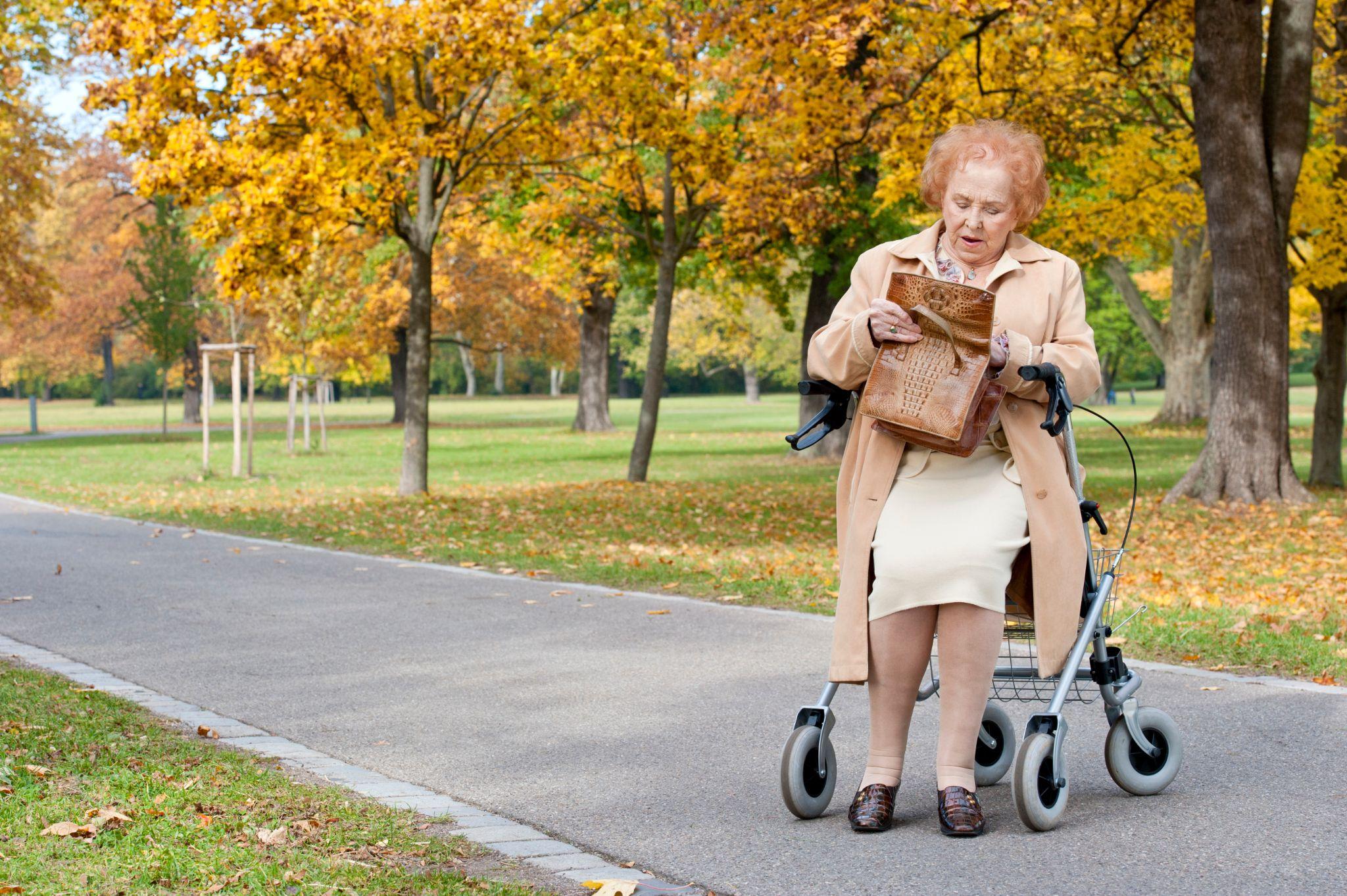 Senior woman using a rollator in a park