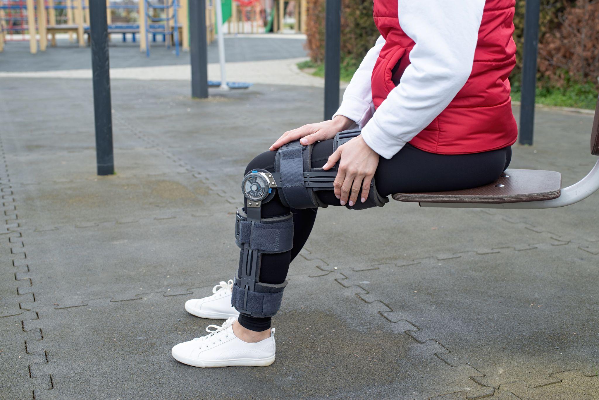 Individual wearing a knee brace outdoors