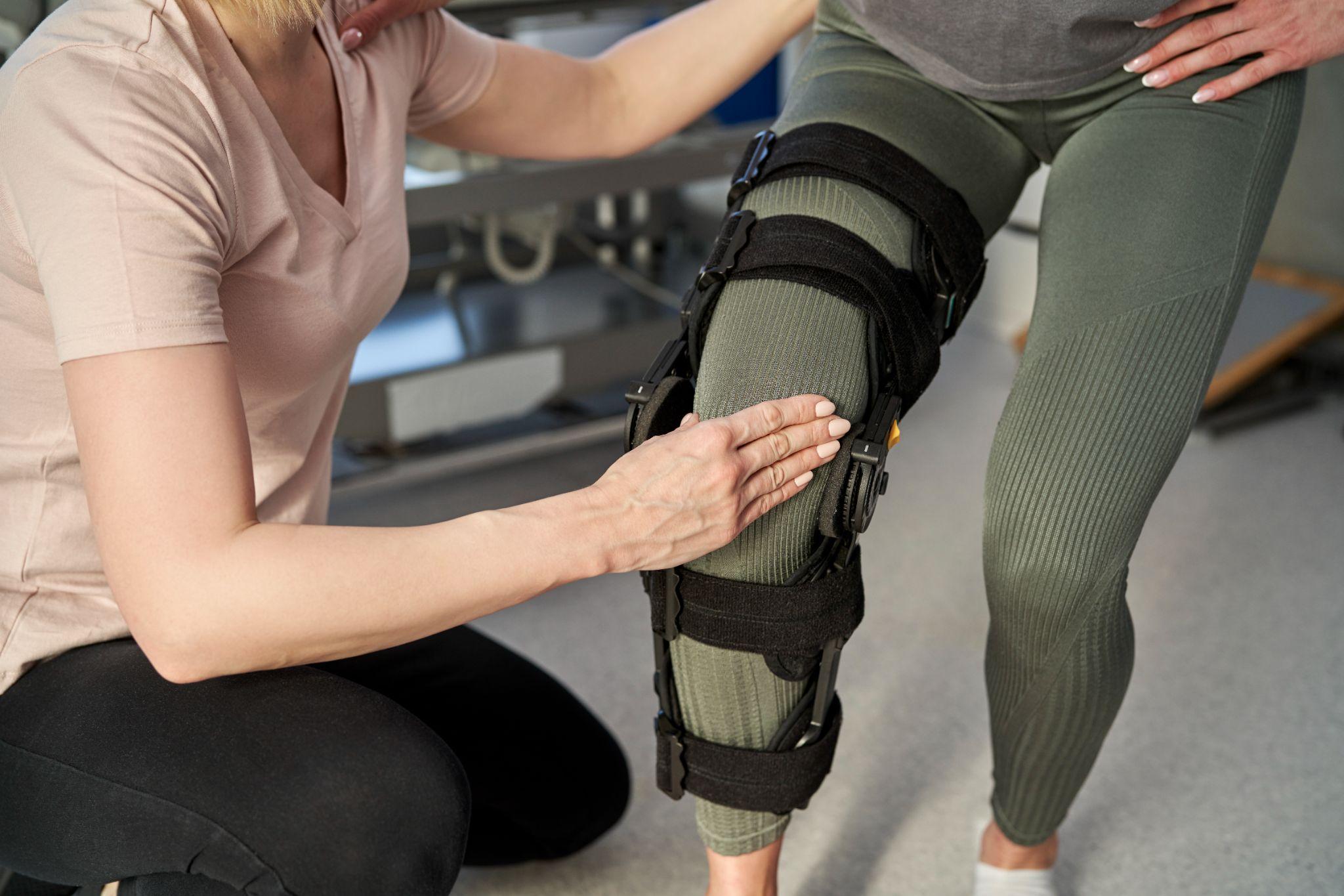 Therapist adjusting knee brace