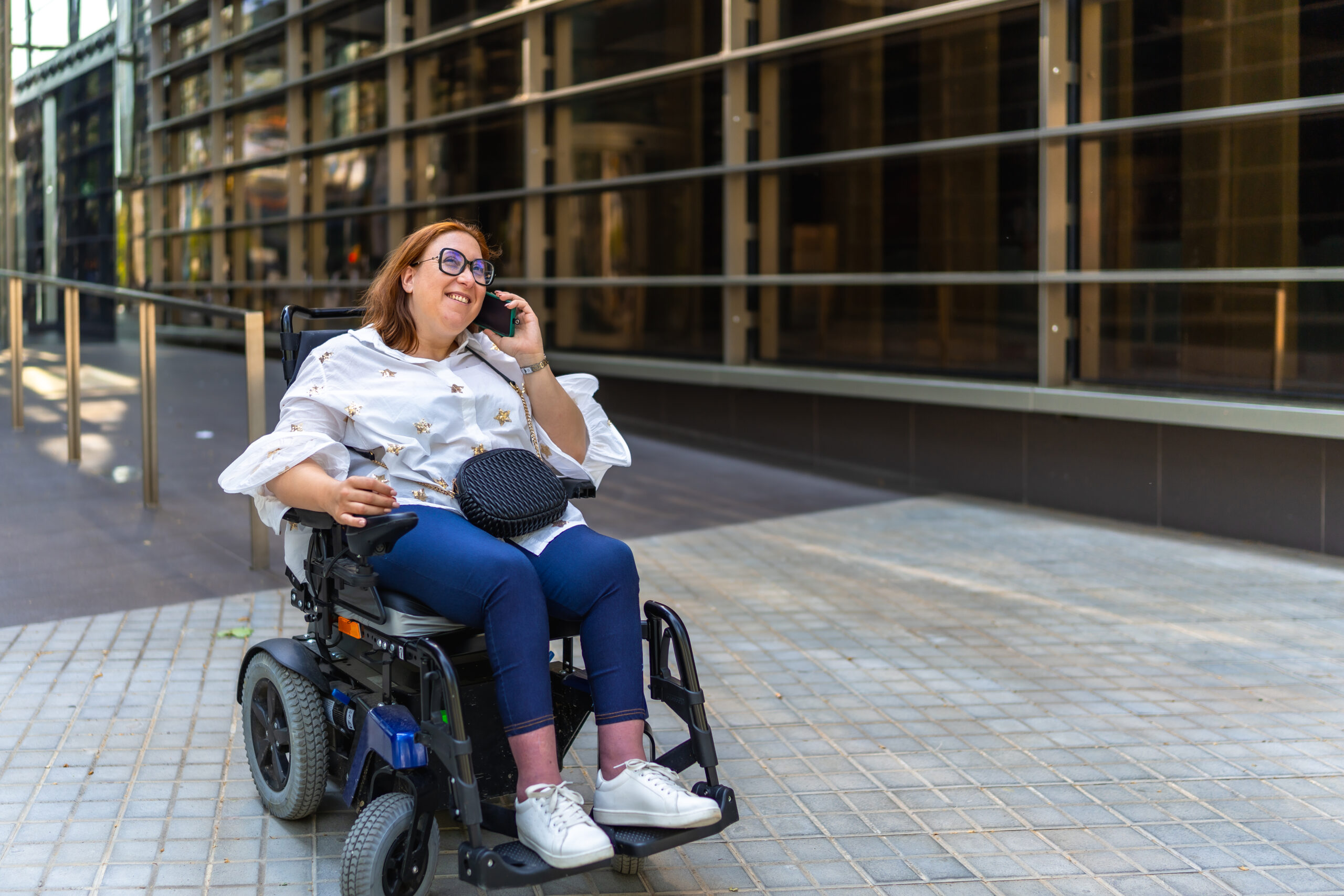 woman in power wheelchair talking on phone