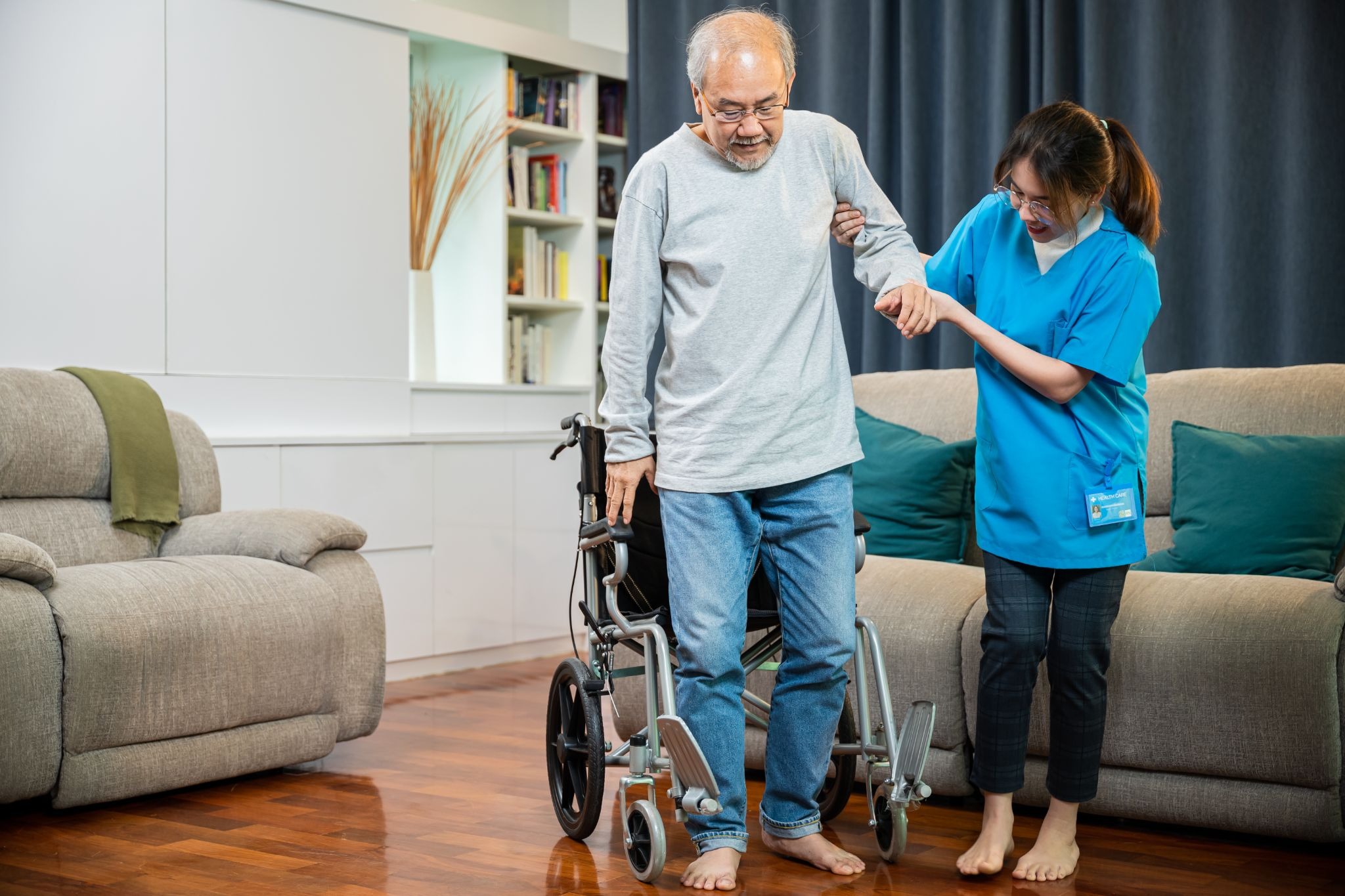 Older adult receiving mobility support from a caregiver at home