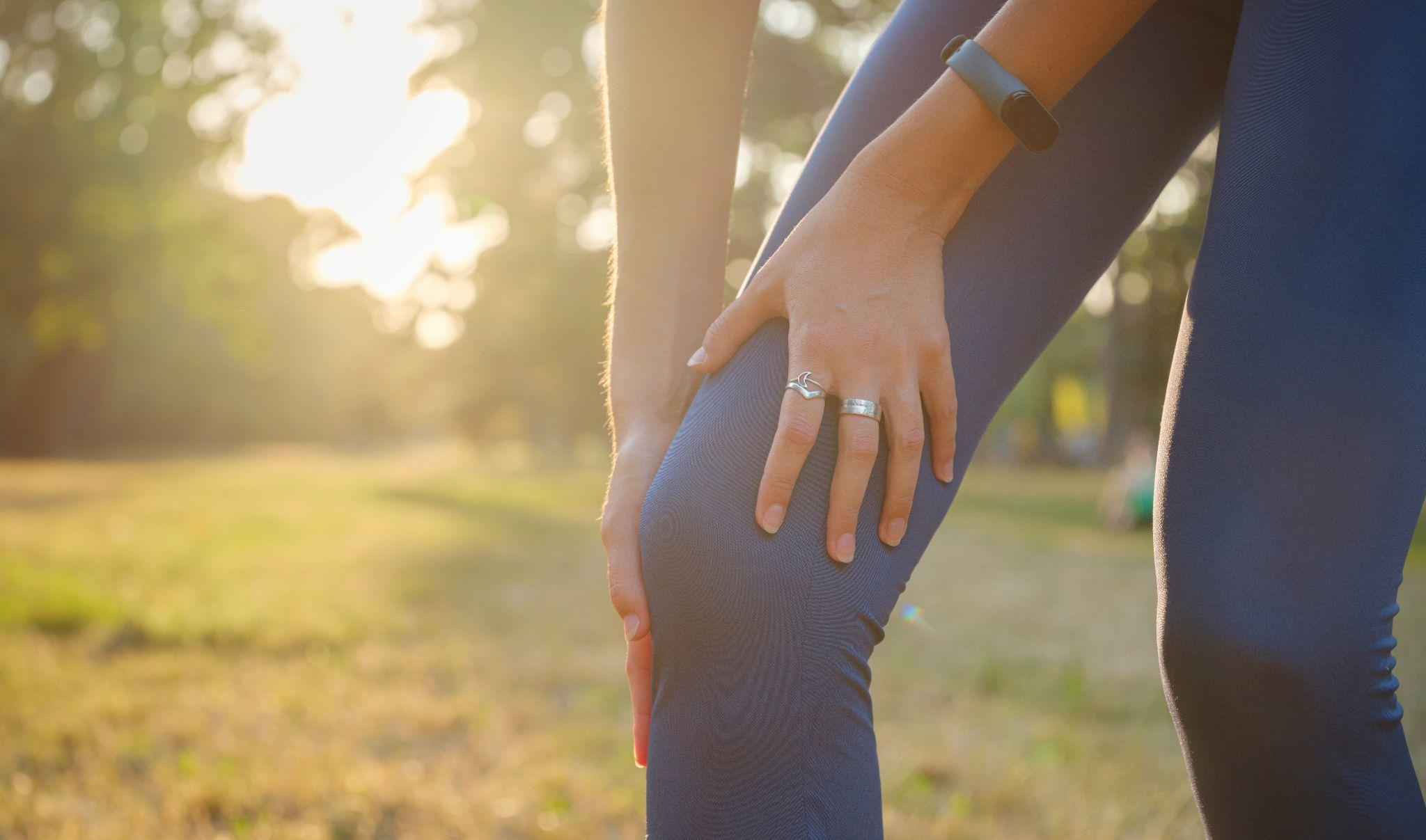Woman holding her knee after exercise while considering joint support for pain and mobility.