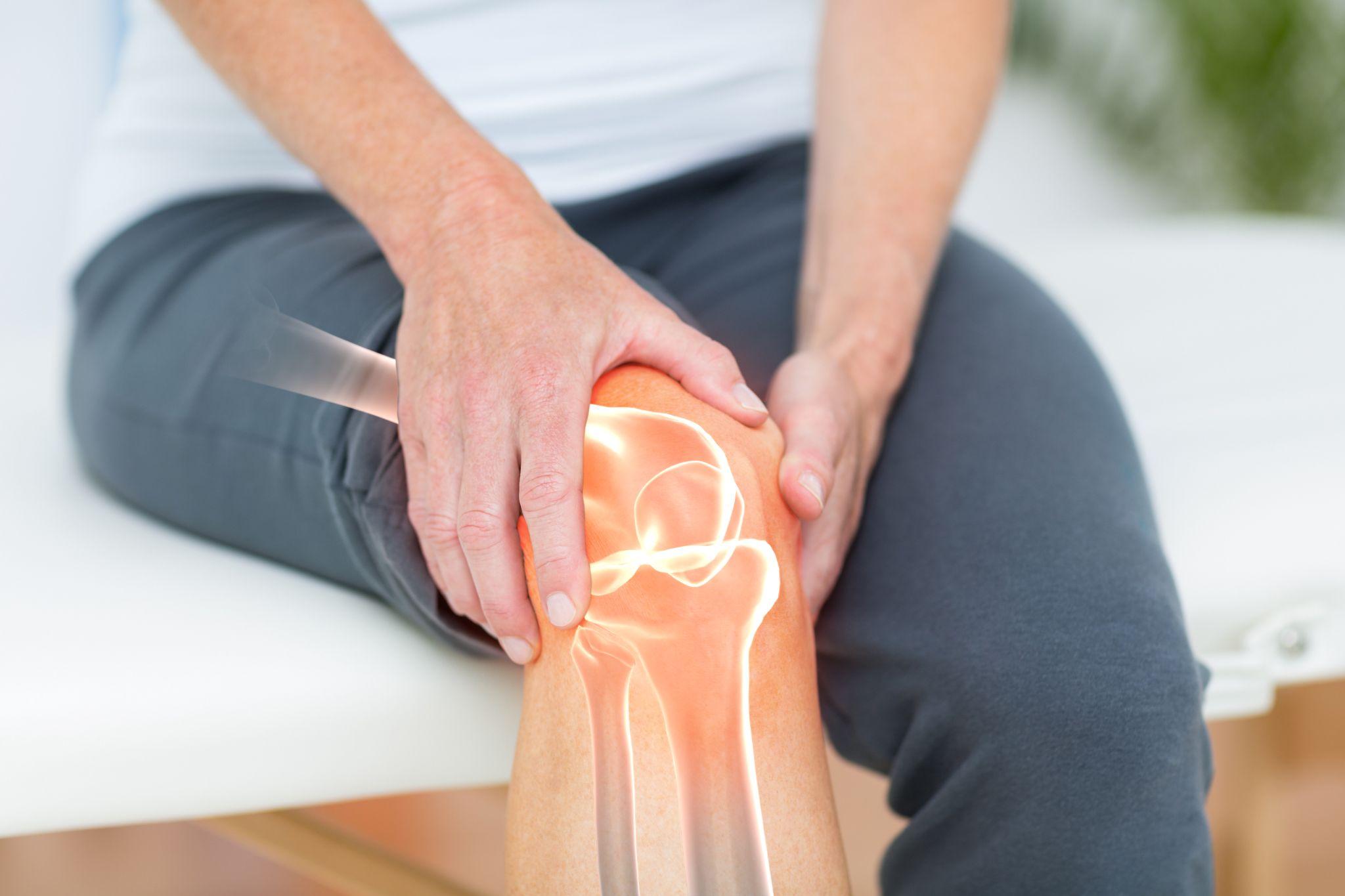 Woman holding a painful knee with a joint illustration highlighting the importance of proper joint support.