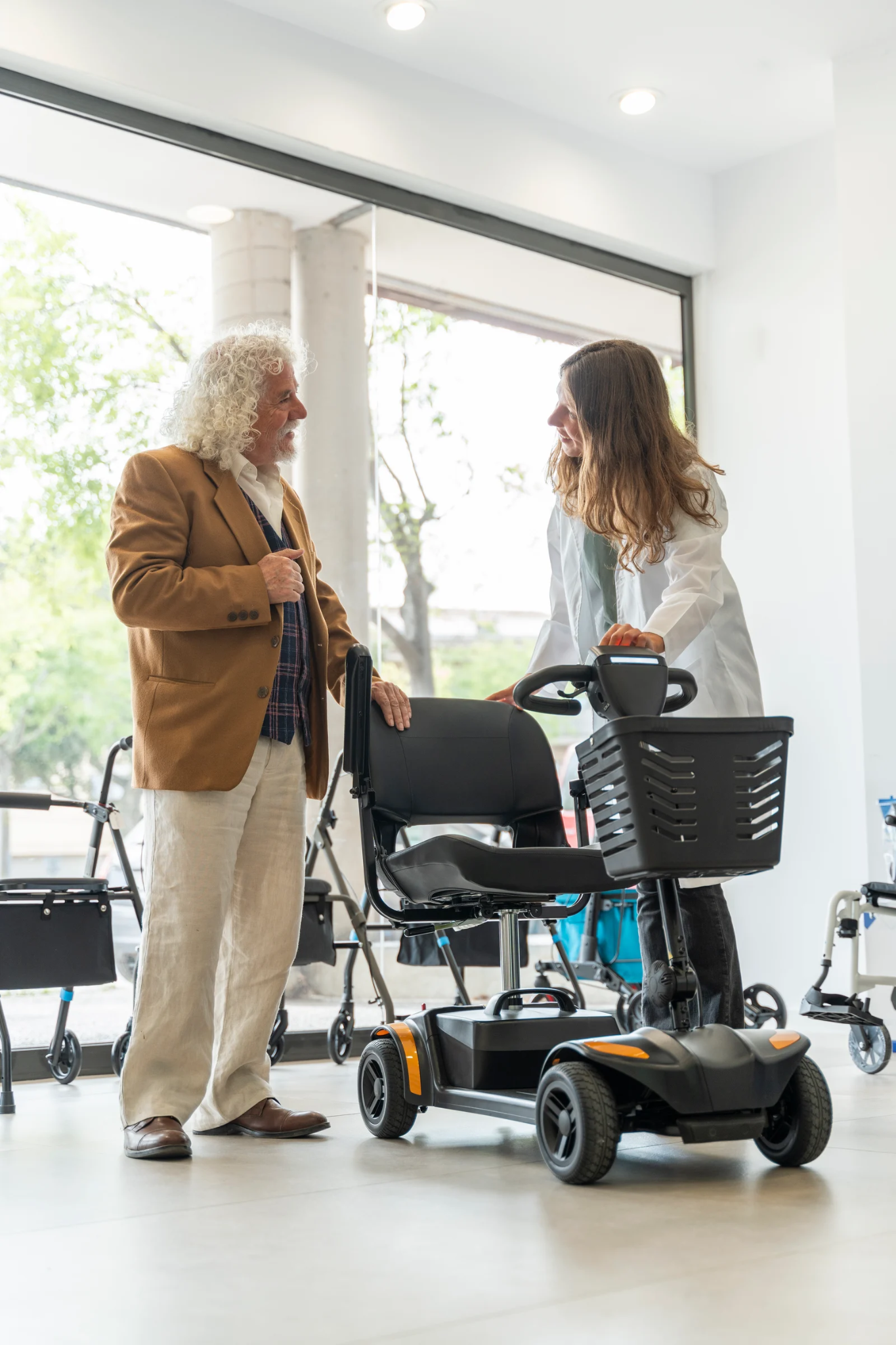 Medical supply specialist helping a customer compare mobility scooters for a Harlingen mobility scooter rental.