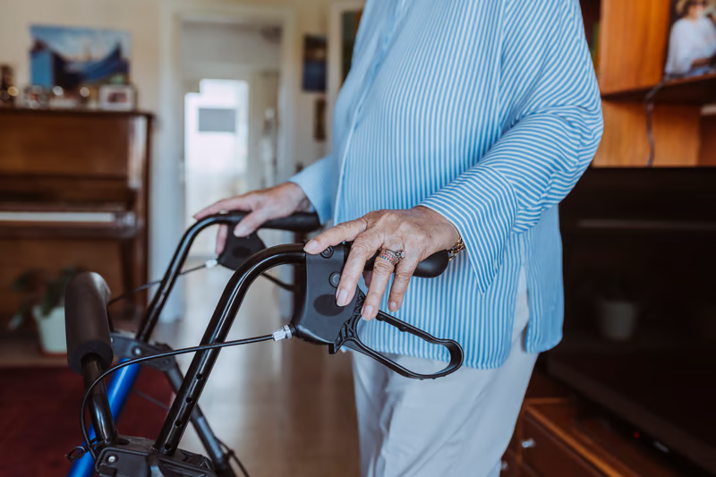 Older adult using a walker at home, showing how home care equipment can support safer mobility and independence.