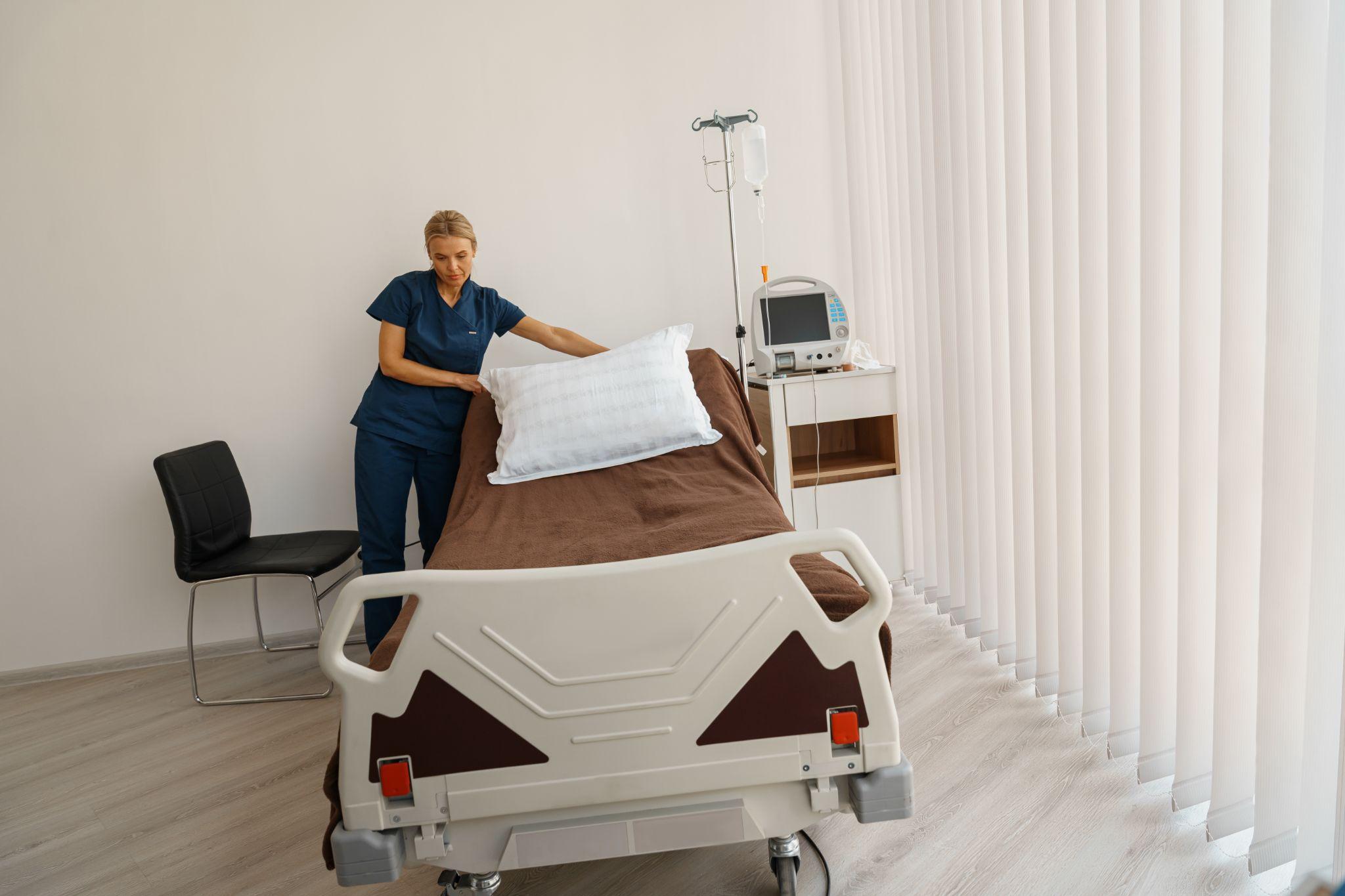 Care provider preparing a hospital bed for safe home use