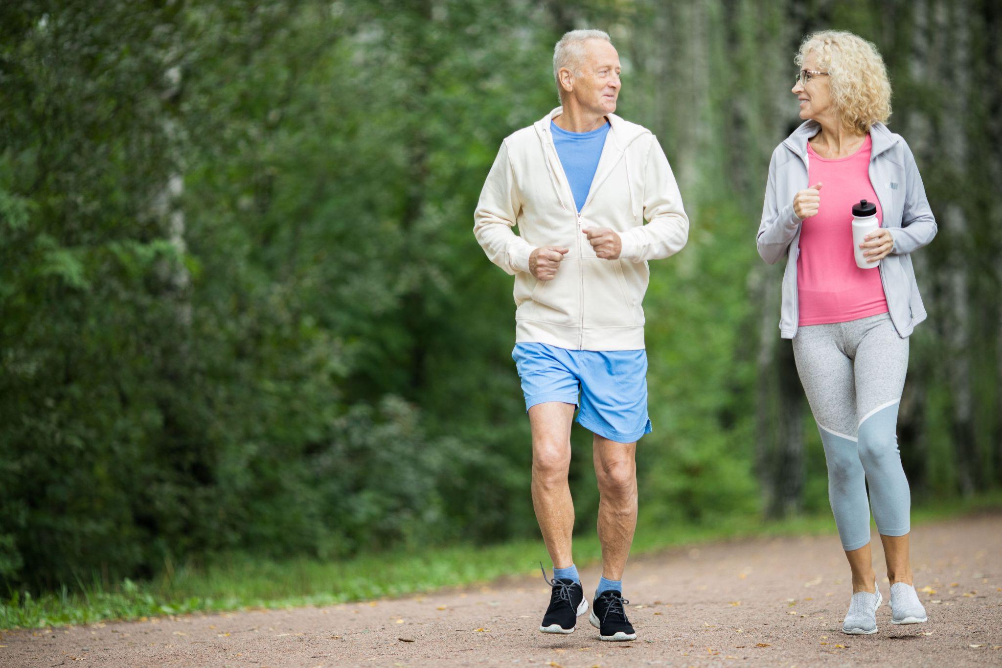 Active senior couple walking outdoors with supportive footwear for everyday mobility