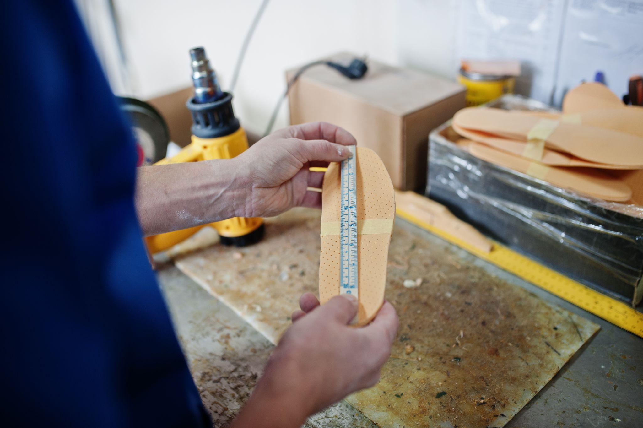 Custom shoe insole being measured during the orthotic fitting process
