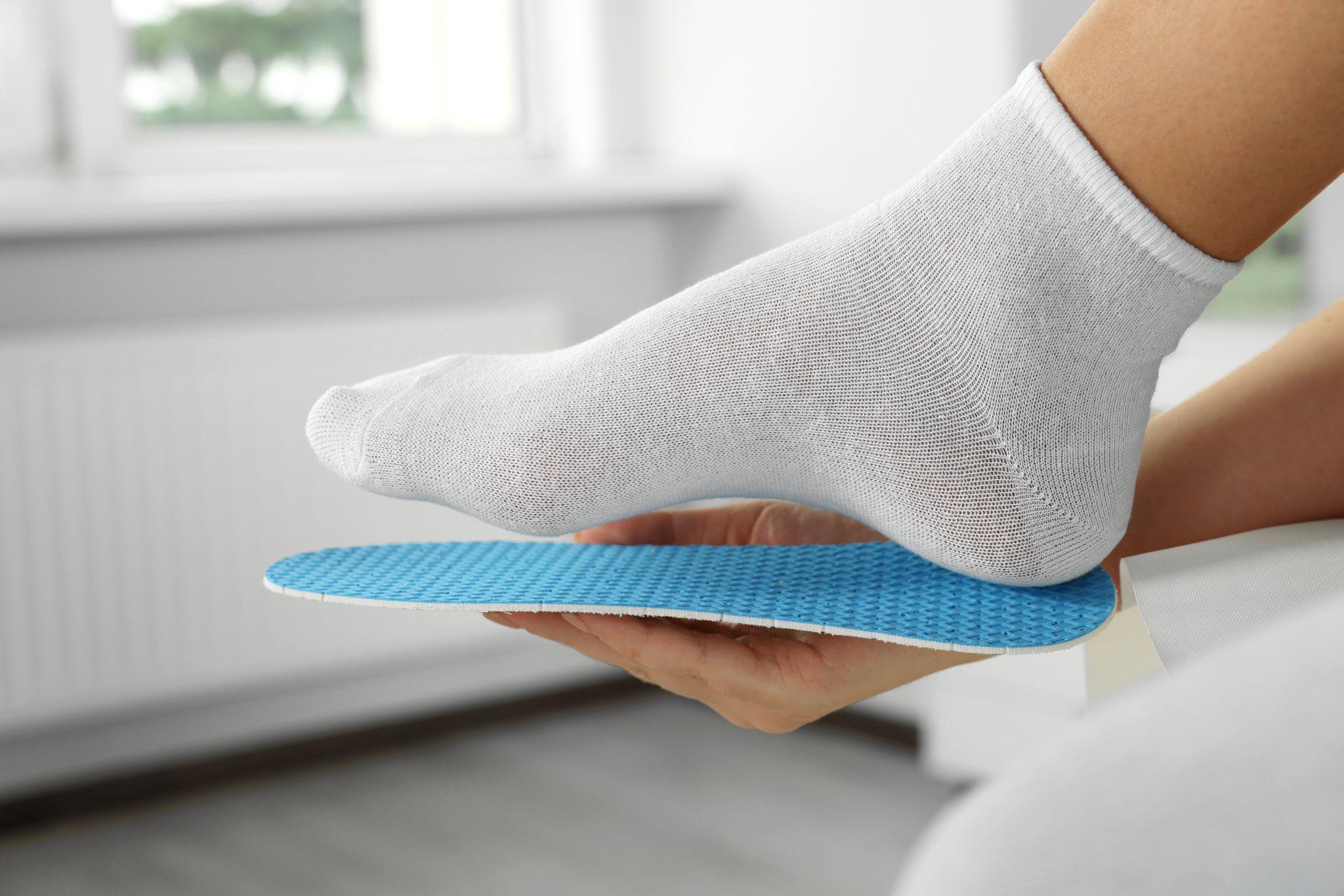 Foot positioned above an orthopedic insole for proper support and fit