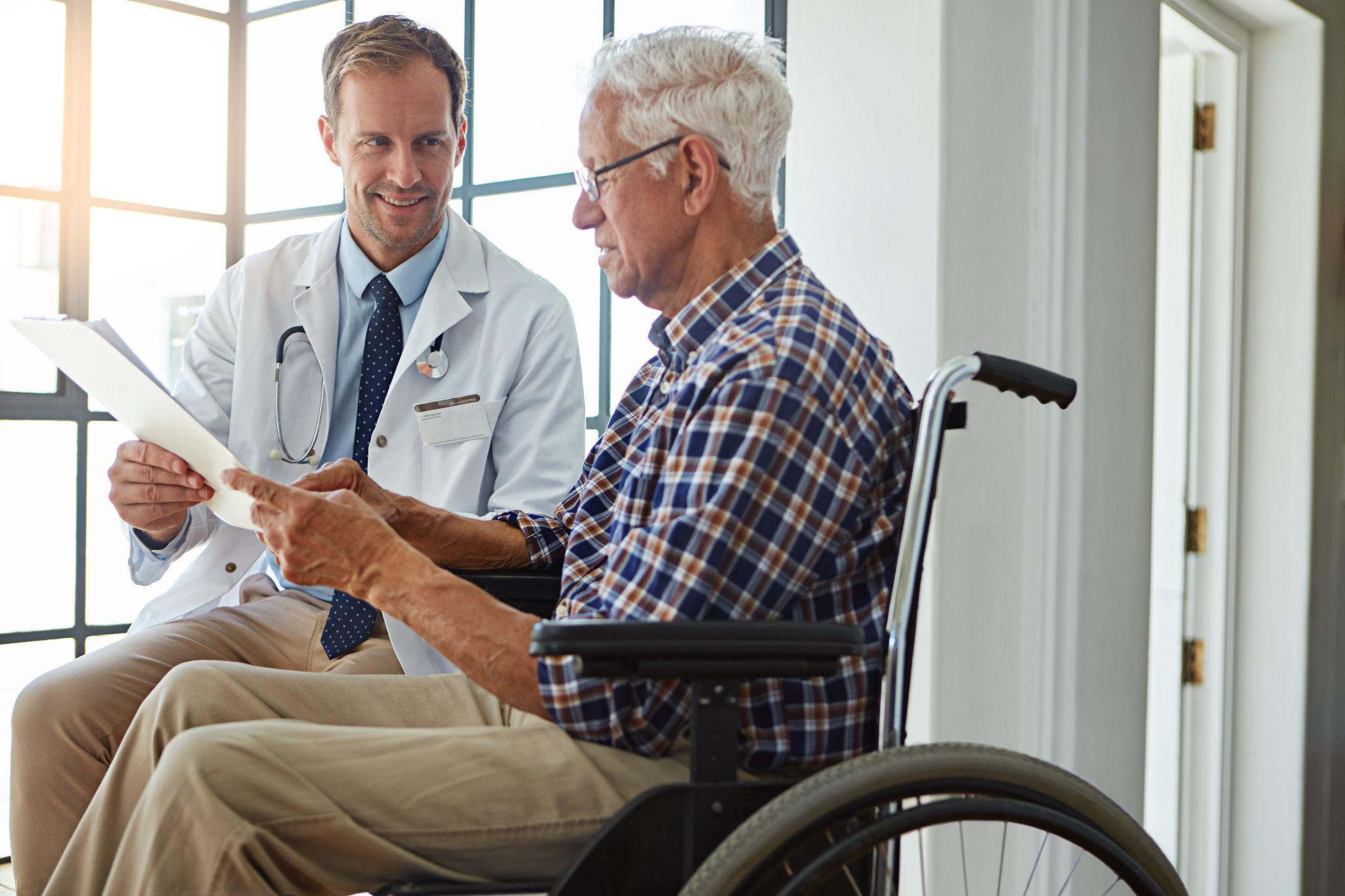 Doctor discussing wheelchair needs with a senior Medicare patient