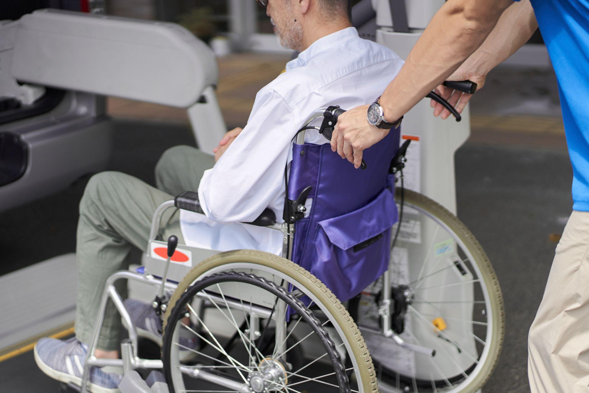 Caregiver assisting a wheelchair user with safe mobility at home