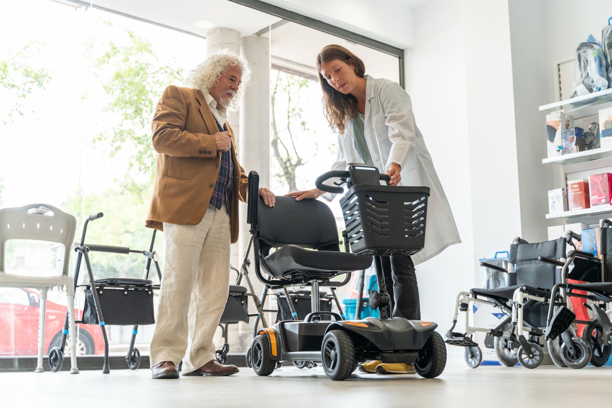 Senior man discussing a mobility scooter with a medical equipment specialist