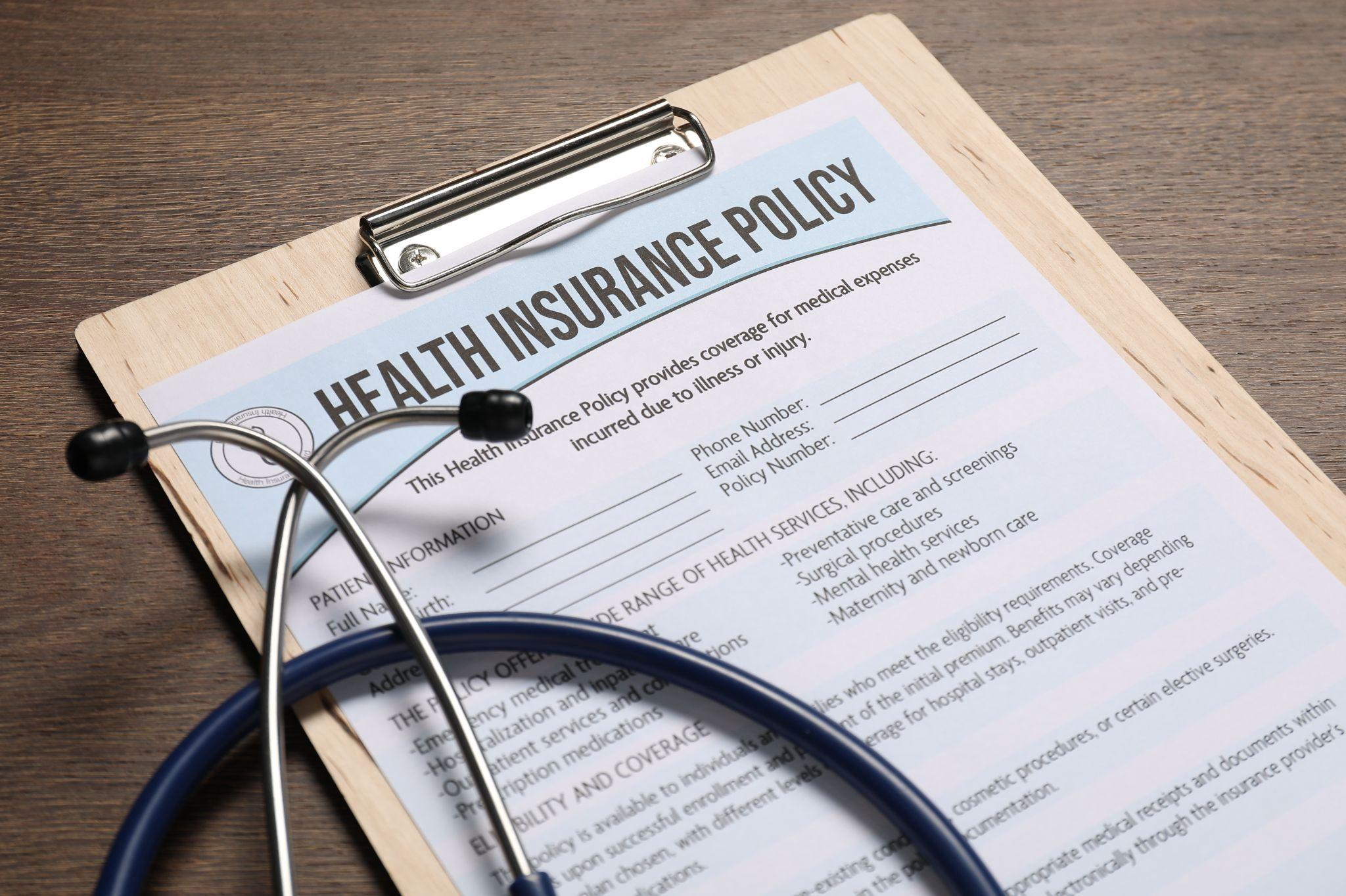 Health insurance policy document and stethoscope representing mobility scooter insurance coverage.
